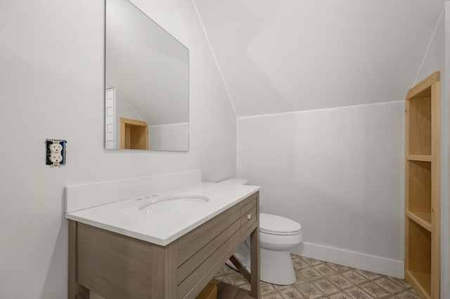 half bathroom featuring vanity, toilet, tile patterned floors, lofted ceiling, and baseboards