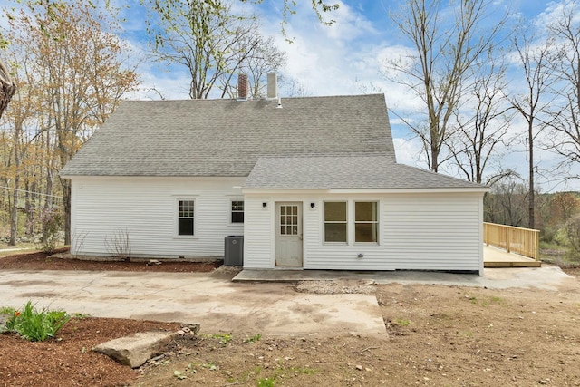 rear view of property featuring a deck, roof with shingles, and central AC unit