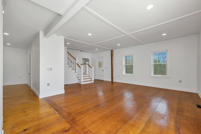 unfurnished living room with stairway, baseboards, wood finished floors, recessed lighting, and beamed ceiling