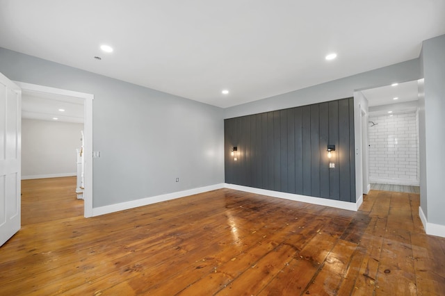 spare room with wood-type flooring, baseboards, and recessed lighting