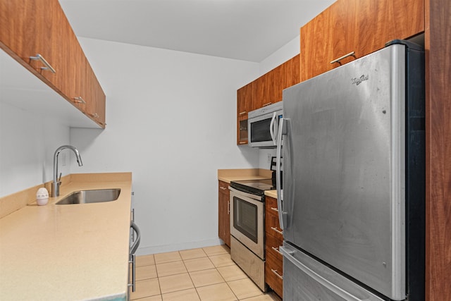 193 St Paul St Unit 101, Burlington, VT 05401 - kitchen featuring appliances with stainless steel finishes, a sink, brown cabinetry, and light tile patterned flooring