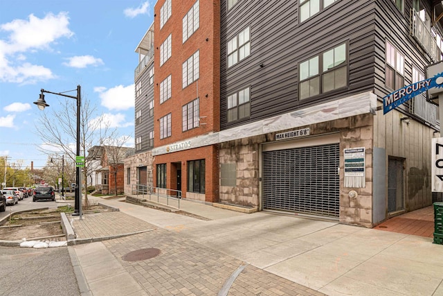 193 St Paul St Unit 101, Burlington, VT 05401 - view of building exterior featuring an attached garage and driveway