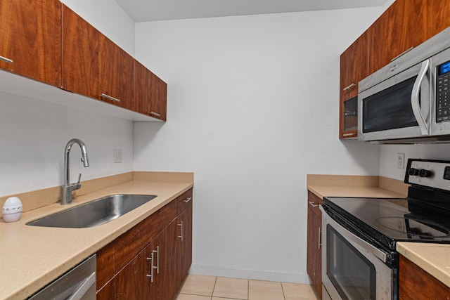 193 St Paul St Unit 101, Burlington, VT 05401 - kitchen featuring appliances with stainless steel finishes, a sink, light countertops, baseboards, and light tile patterned floors