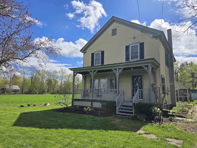 view of front of home featuring covered porch, a chimney, and a front yard
