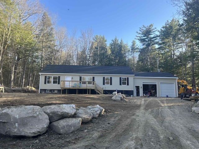 29 Igls Ln, Conway, NH 03818 - view of front facade featuring a garage, a deck, dirt driveway, and stairs