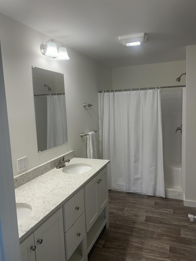 29 Igls Ln, Conway, NH 03818 - bathroom featuring double vanity, wood finished floors, and shower / bath combo with shower curtain