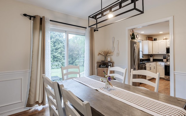 dining room with wainscoting and light wood-style flooring
