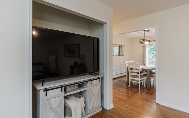 hall with wood finished floors and a chandelier