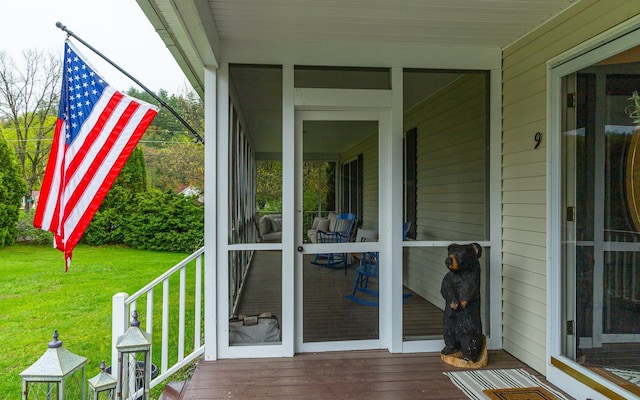 deck featuring a yard and a sunroom