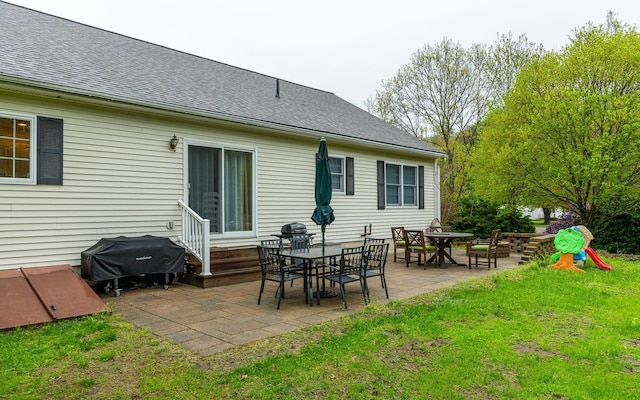 back of property featuring a patio, a lawn, and a shingled roof