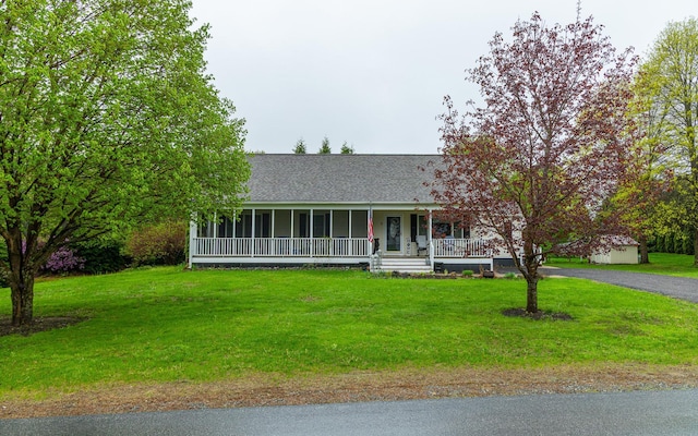 view of front of home featuring covered porch, a front lawn, and roof with shingles