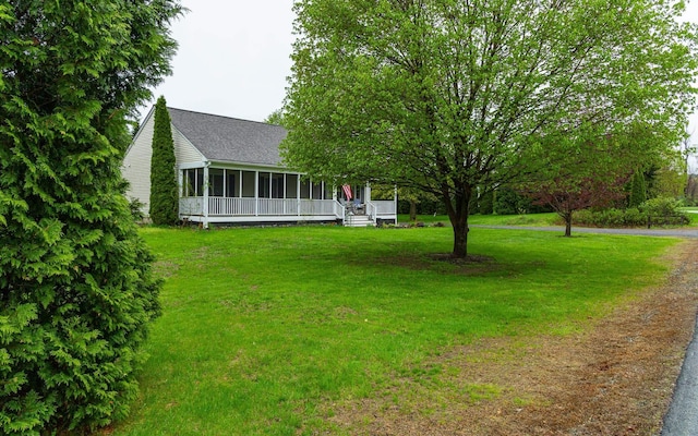 view of grassy yard featuring a sunroom