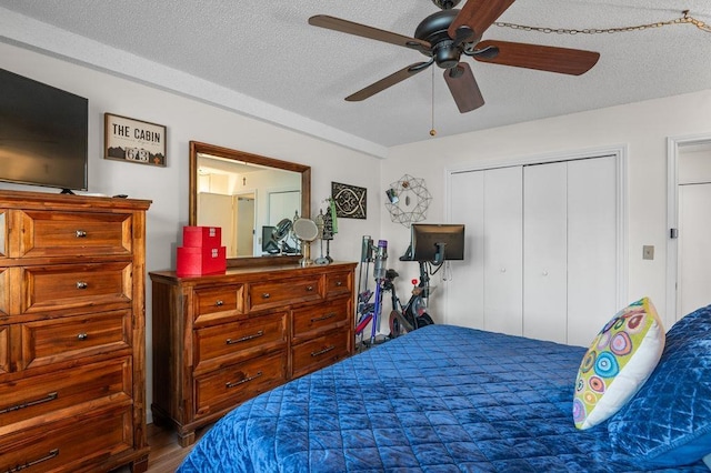 bedroom featuring a textured ceiling, wood finished floors, a closet, and a ceiling fan