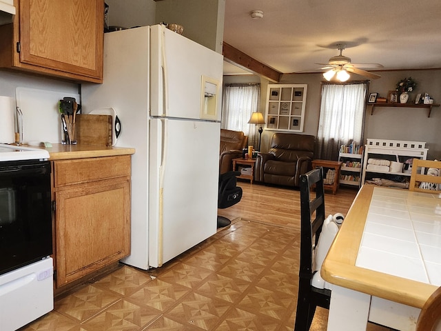 kitchen featuring electric stove, freestanding refrigerator, a ceiling fan, open floor plan, and under cabinet range hood
