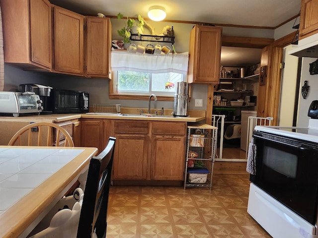 kitchen featuring electric range oven, tile countertops, a sink, black microwave, and brown cabinetry