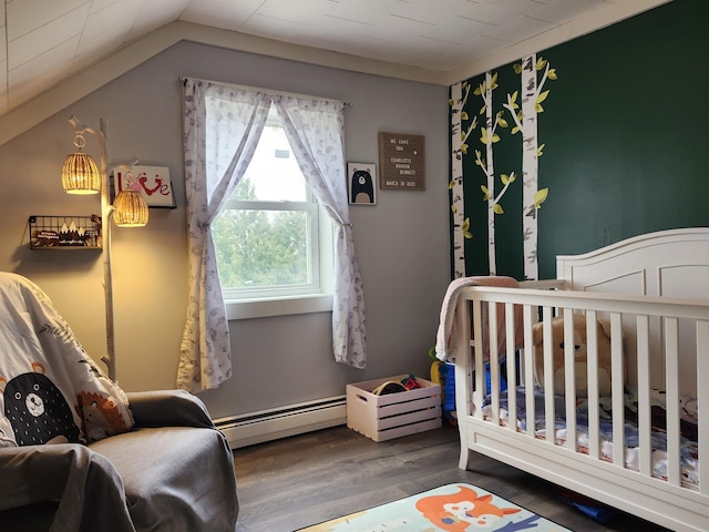 bedroom with baseboard heating, wood finished floors, vaulted ceiling, and a crib