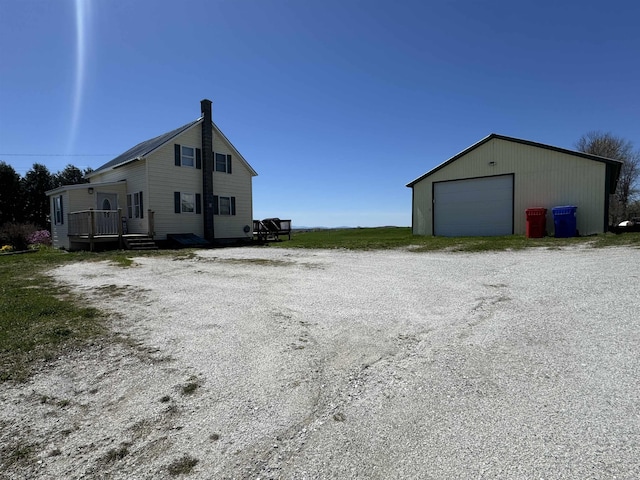 view of side of home with a garage and an outbuilding