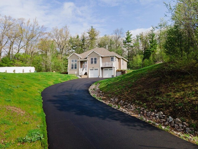 11 Carriage Hill Rd, Wilton, NH 03086 - view of front of house featuring asphalt driveway, a garage, and a front lawn