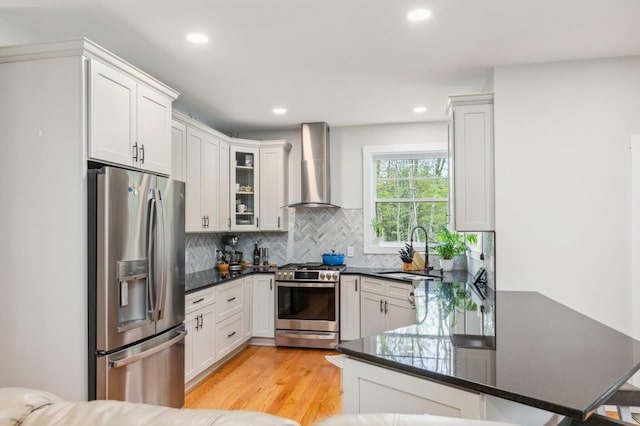 11 Carriage Hill Rd, Wilton, NH 03086 - kitchen with appliances with stainless steel finishes, wall chimney range hood, a sink, a peninsula, and backsplash