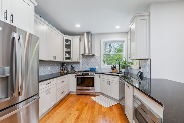 11 Carriage Hill Rd, Wilton, NH 03086 - kitchen featuring appliances with stainless steel finishes, a sink, wall chimney range hood, light wood finished floors, and decorative backsplash