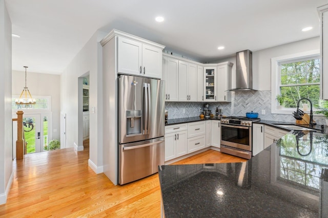 11 Carriage Hill Rd, Wilton, NH 03086 - kitchen with stainless steel appliances, wall chimney exhaust hood, a sink, decorative backsplash, and dark stone countertops