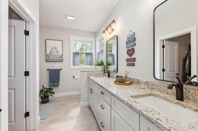 11 Carriage Hill Rd, Wilton, NH 03086 - bathroom with double vanity, baseboards, tile patterned flooring, and toilet