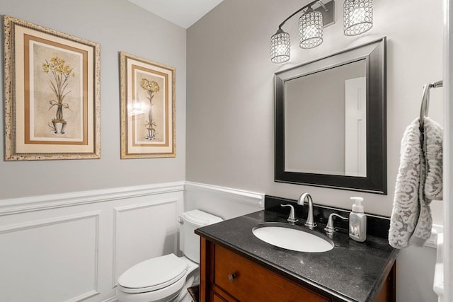 12 Mcintosh Ln, Bedford, NH 03110 - half bathroom featuring toilet, vanity, and a wainscoted wall