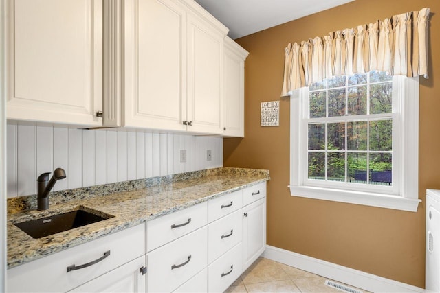 12 Mcintosh Ln, Bedford, NH 03110 - kitchen with a sink, white cabinetry, baseboards, light stone counters, and light tile patterned floors