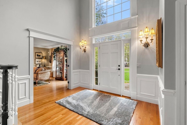 12 Mcintosh Ln, Bedford, NH 03110 - entryway featuring a decorative wall, a towering ceiling, wood finished floors, and wainscoting