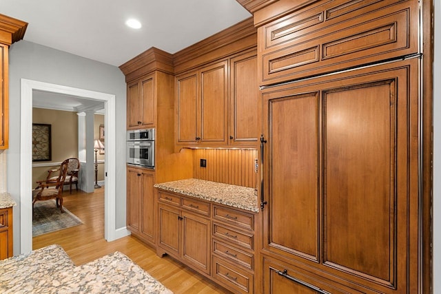 12 Mcintosh Ln, Bedford, NH 03110 - kitchen featuring oven, light wood-style floors, light stone counters, brown cabinetry, and recessed lighting