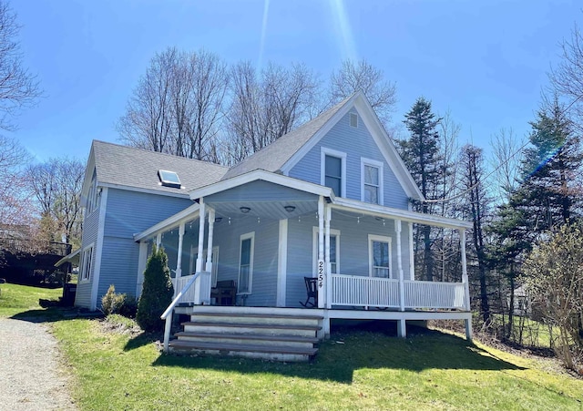 view of front of house with a porch, a front lawn, and roof with shingles