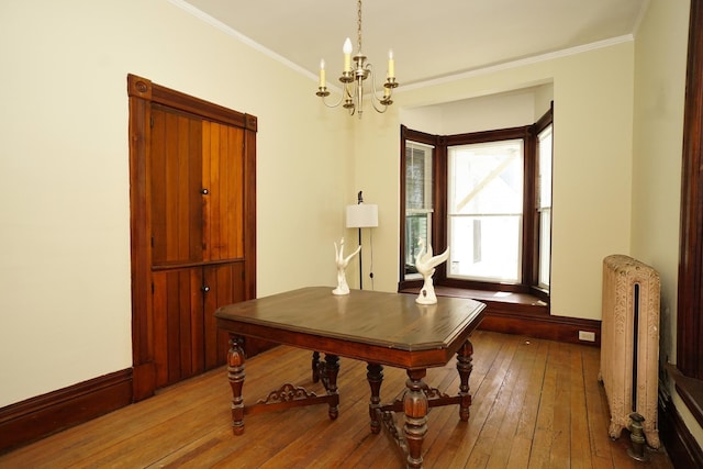 489 Hanover St, Manchester, NH 03104 - dining space with a chandelier, radiator heating unit, hardwood / wood-style flooring, and crown molding