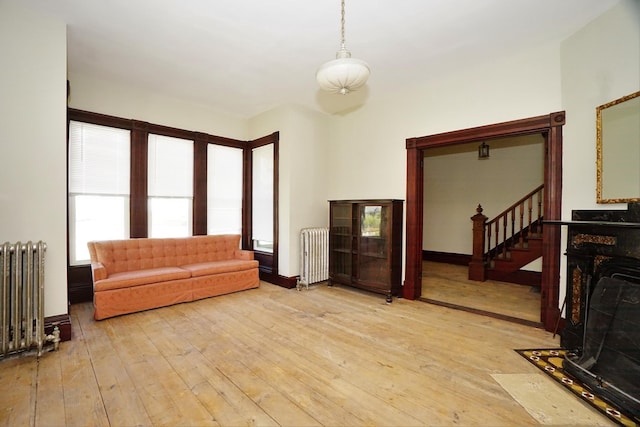 489 Hanover St, Manchester, NH 03104 - living area featuring radiator heating unit, light wood-style floors, and stairs