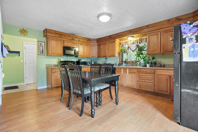 28 Putnam Hill Rd, Lyndeborough, NH 03082 - kitchen with black appliances, a textured ceiling, light wood-style flooring, light countertops, and brown cabinetry