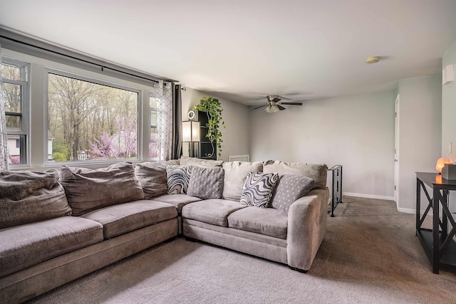 carpeted living area with a ceiling fan, plenty of natural light, and baseboards