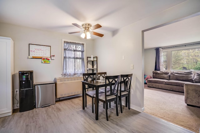 dining room featuring ceiling fan, light wood finished floors, radiator heating unit, and baseboards