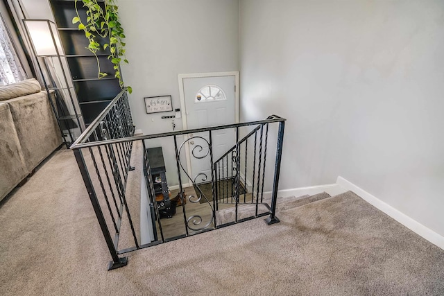 staircase featuring carpet and baseboards