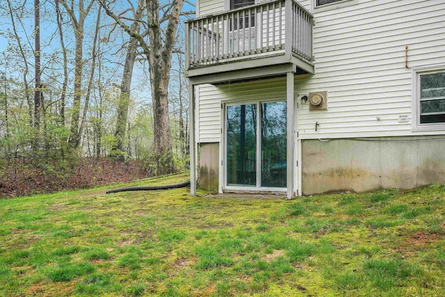rear view of house with a balcony and a lawn