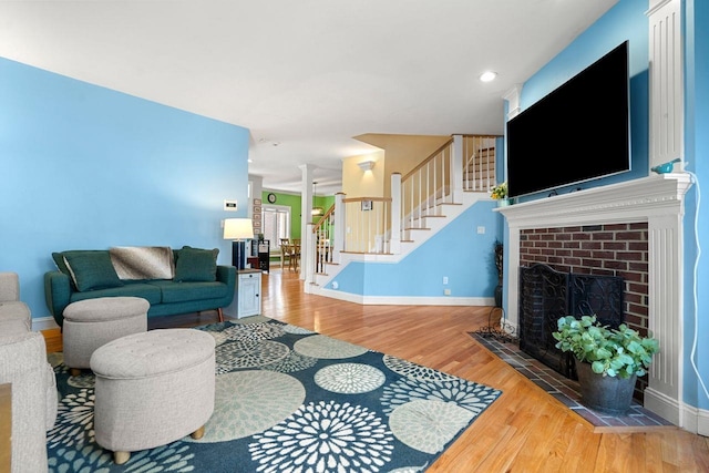 38 Farmington Rd, Nashua, NH 03060 - living room featuring stairway, wood finished floors, baseboards, a fireplace, and ornate columns
