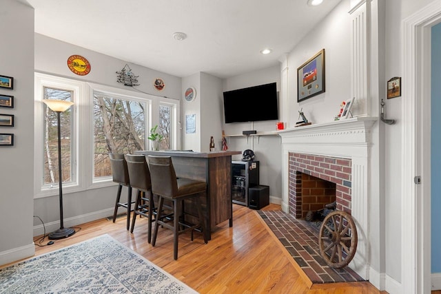 38 Farmington Rd, Nashua, NH 03060 - bar featuring baseboards, light wood-style flooring, a brick fireplace, and recessed lighting