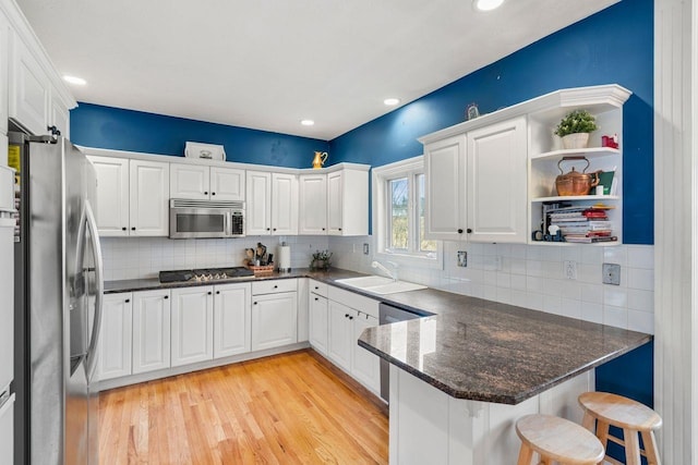 38 Farmington Rd, Nashua, NH 03060 - kitchen featuring stainless steel appliances, a sink, a peninsula, white cabinetry, and recessed lighting