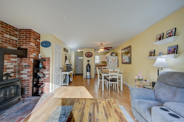 45 Haynesville Ave Unit 3, Conway, NH 03818 - living area featuring a wood stove, wood finished floors, ceiling fan, and baseboards