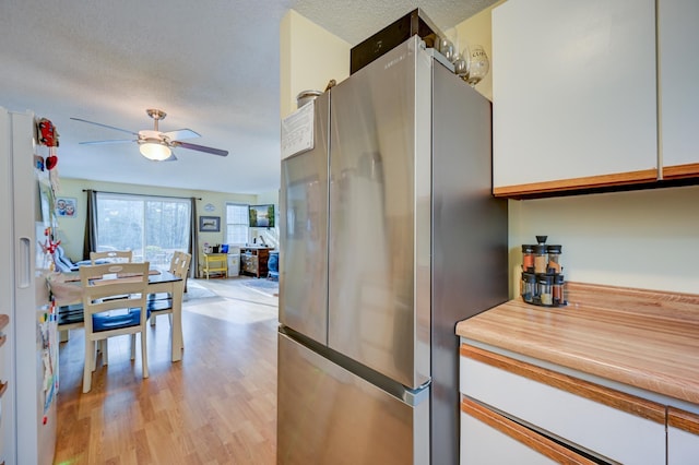 45 Haynesville Ave Unit 3, Conway, NH 03818 - kitchen featuring freestanding refrigerator, ceiling fan, light wood-style flooring, open floor plan, and white cabinets
