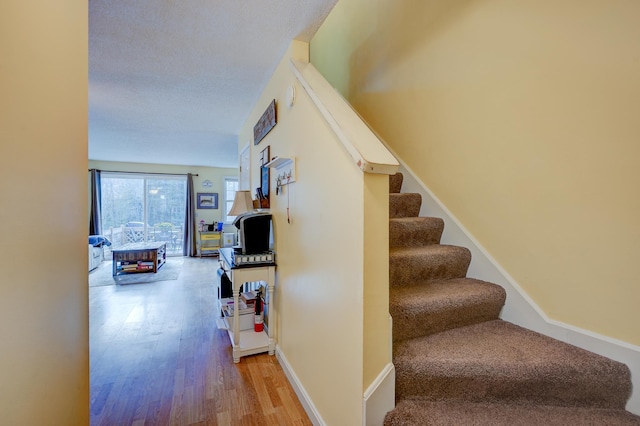 45 Haynesville Ave Unit 3, Conway, NH 03818 - stairway featuring wood finished floors and a textured ceiling