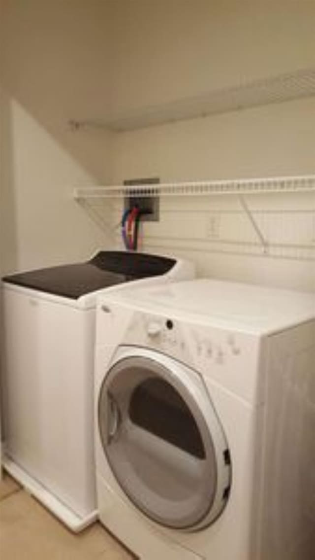 161 St Paul St Unit 001, Burlington, VT 05401 - clothes washing area featuring washer and clothes dryer and light tile patterned flooring