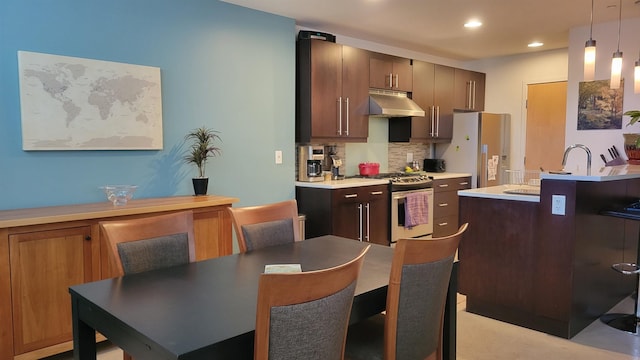 161 St Paul St Unit 001, Burlington, VT 05401 - kitchen with under cabinet range hood, appliances with stainless steel finishes, tasteful backsplash, decorative light fixtures, and recessed lighting