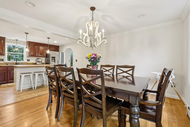 dining space featuring a chandelier, a baseboard heating unit, light wood finished floors, ornamental molding, and recessed lighting