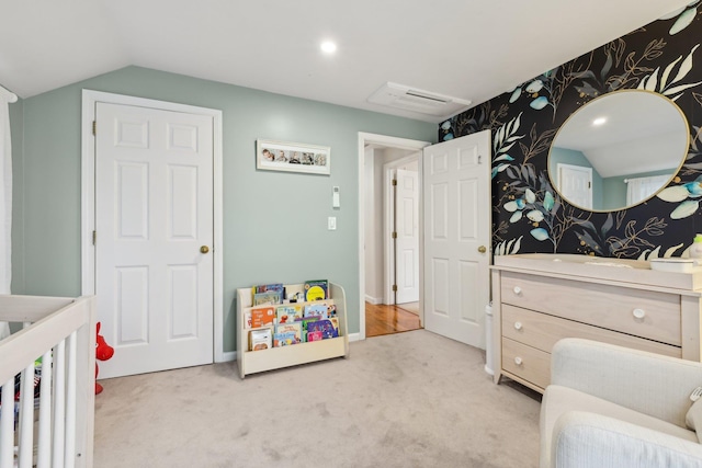 bedroom featuring wallpapered walls, light colored carpet, and lofted ceiling