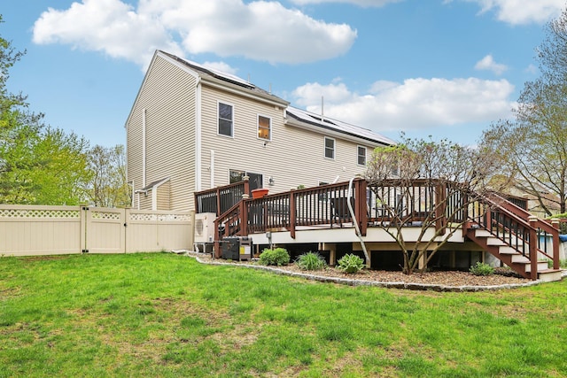 back of property with a gate, a wooden deck, and stairs