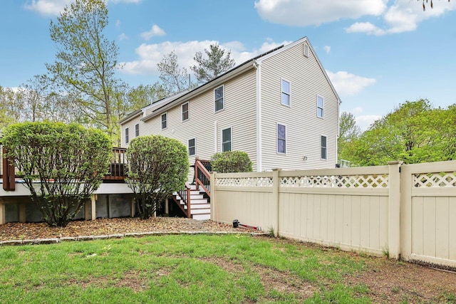 rear view of property featuring a wooden deck and stairs